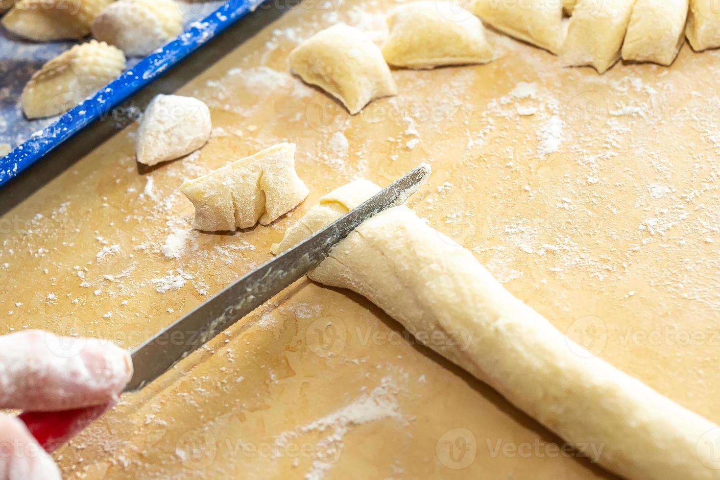 Old woman hands preparing fresh italian pasta gnocchi. Concept Italian Traditional cuisine photo