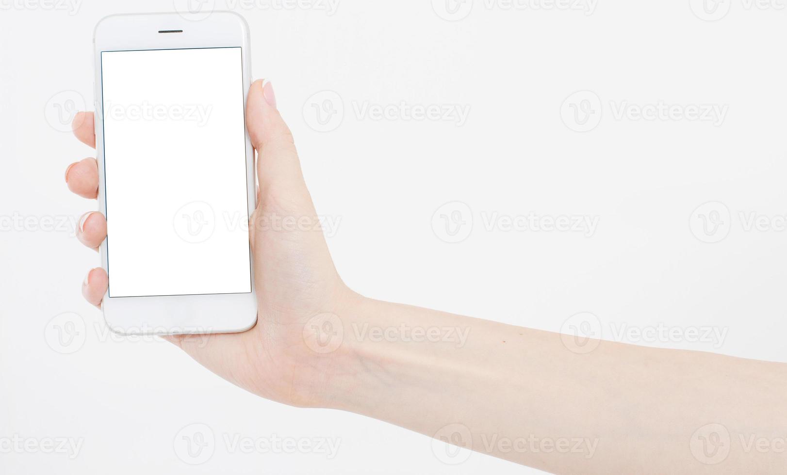 Asimiento de la mano femenina teléfono móvil aislado en blanco, mujer sosteniendo el teléfono con pantalla vacía, pantalla en blanco, tocando foto