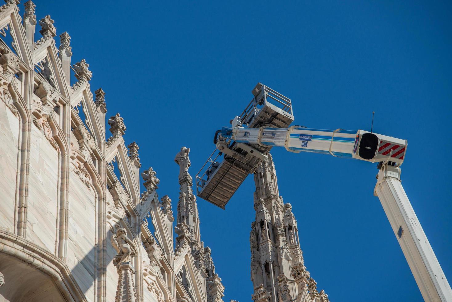 Milán Italia 2021 técnicos en plataforma elevadora para plan de mantenimiento programado y estudio de los fenómenos de degradación de la catedral de Milán foto