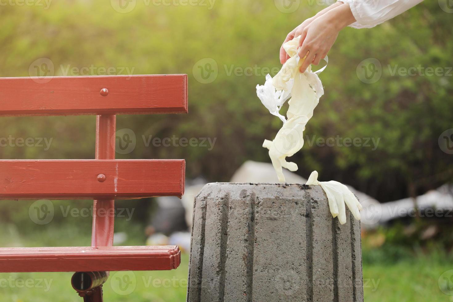 Coronavirus quarantine is over. Woman hand throwing used masks and gloves in a trash outdoors. World coronavirus outbreak. Global pandemic, Covid-19. selective focus. photo