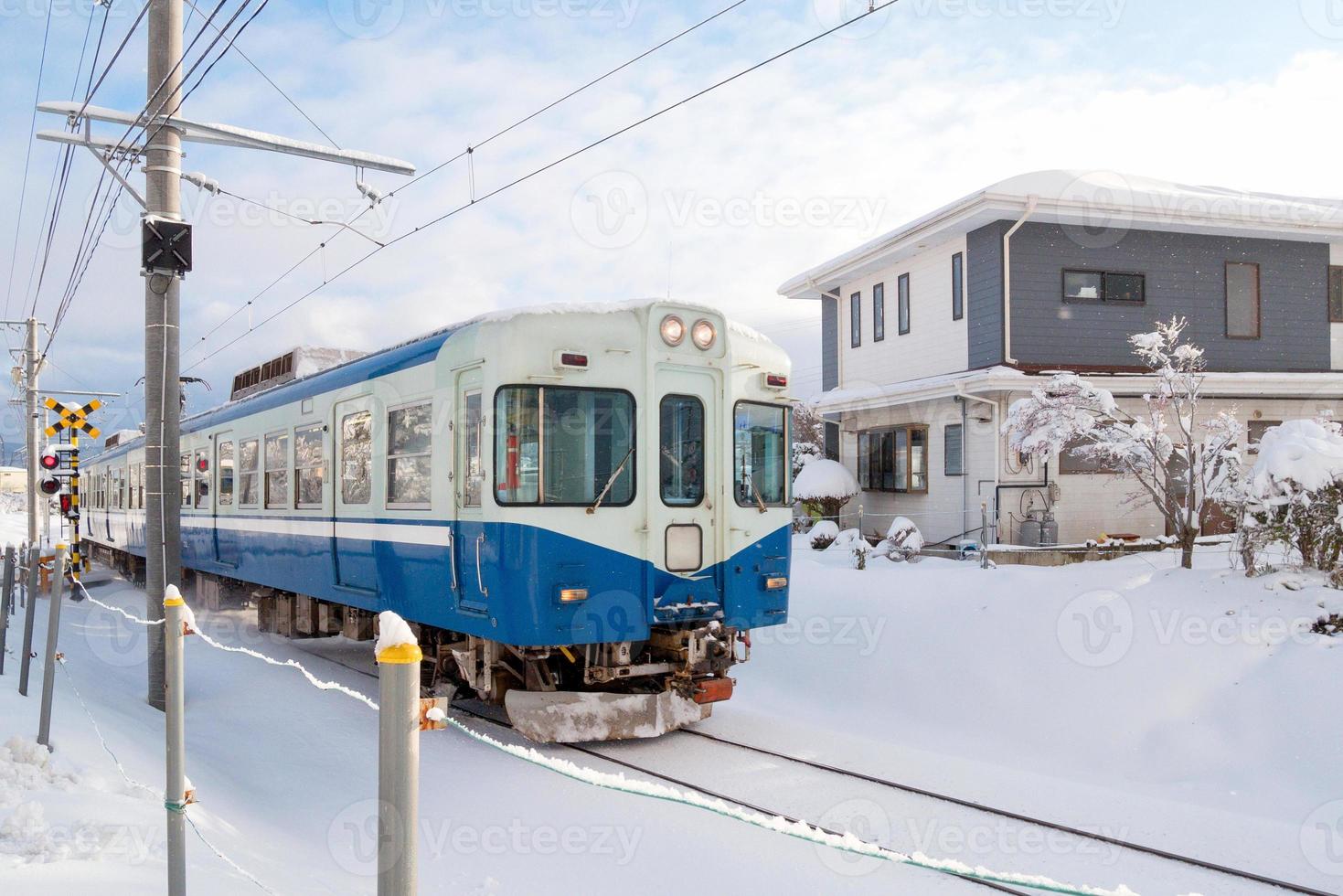 Train moving on railway track for local train with white snow fall in winter season,Japan photo