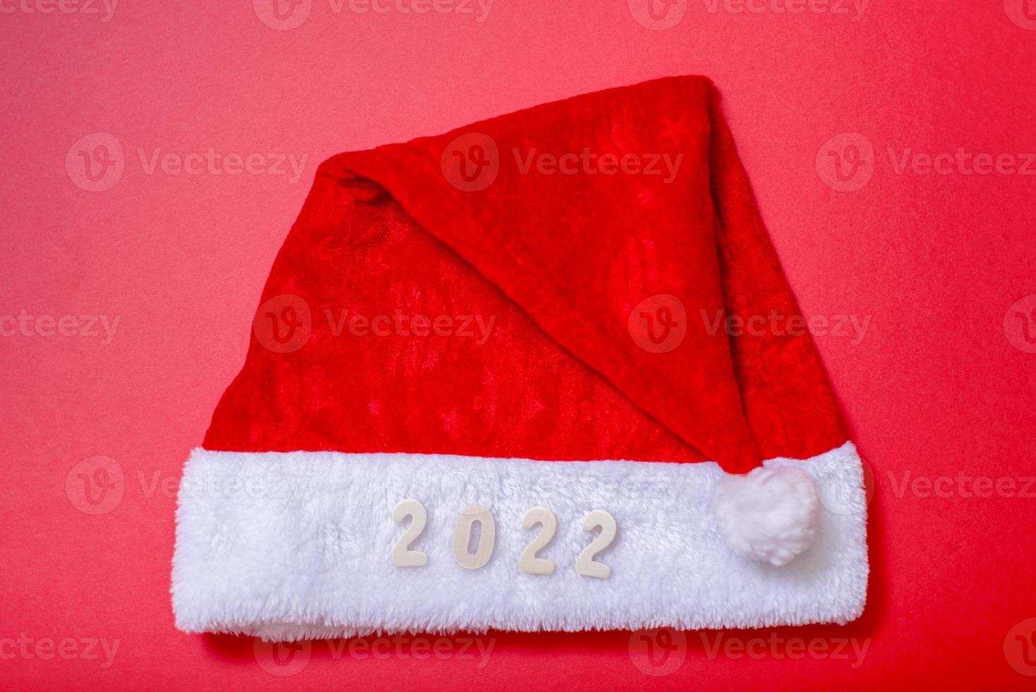 Santa's hat and the numbers of 2022 on a red background. photo