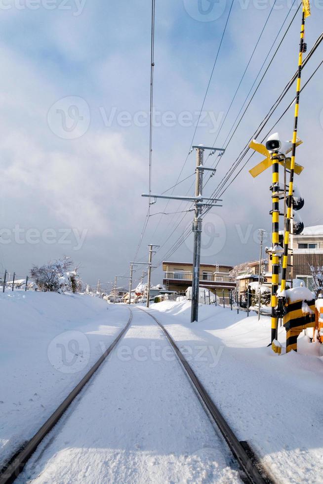 Railway track for local train with white snow fall in winter season,Japan photo