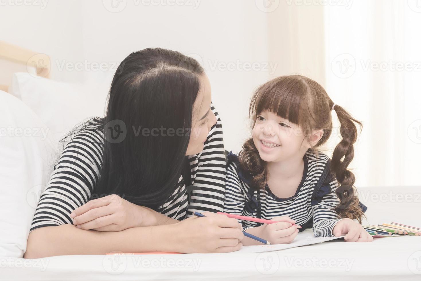 Happy family in the bedroom,Asian mother teaching her daughter child to learning for  preschool. Photo design for family, children and happy people concept.