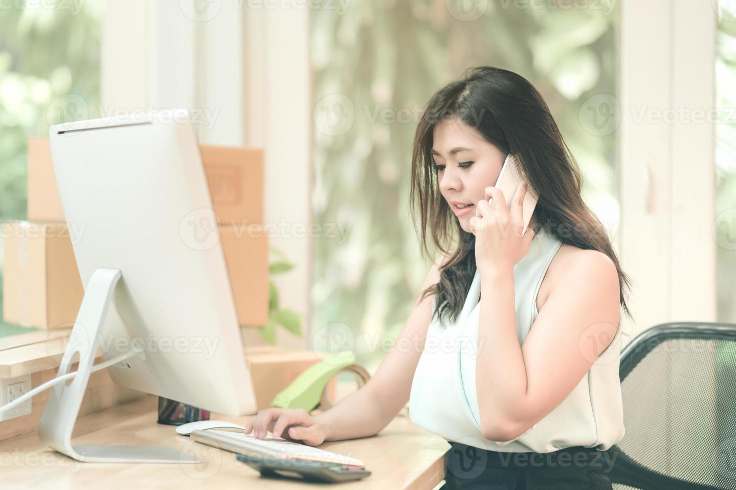 empresaria asiática que trabaja en la computadora inteligente mientras habla con su cliente en la oficina en casa. conceptual para pequeñas empresas que inician su propia empresa y marketing en línea. foto