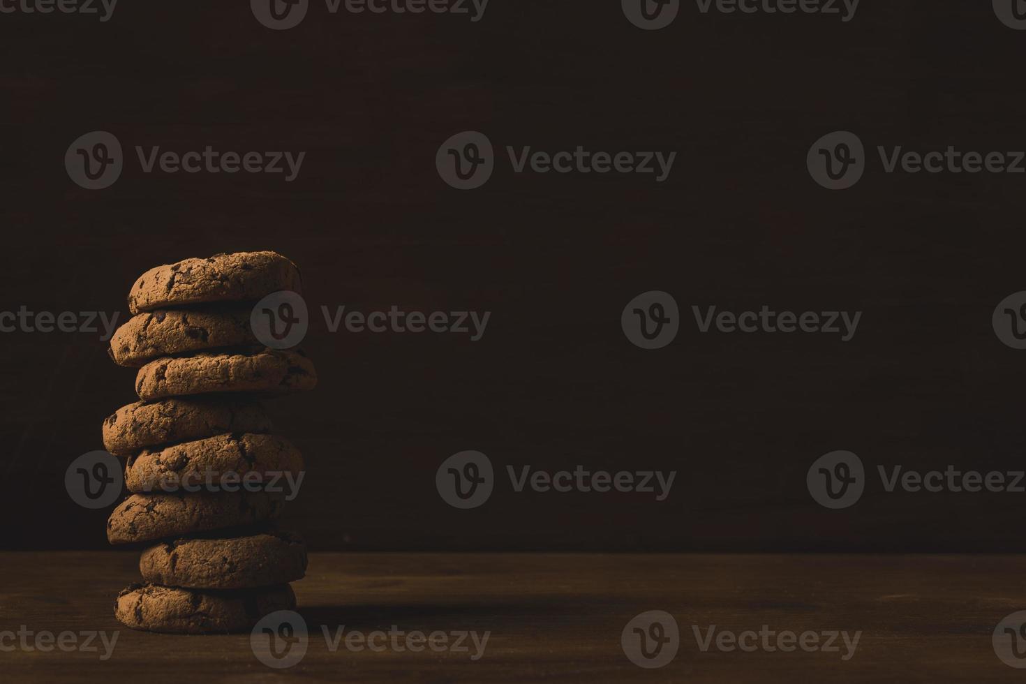 Una torre de galletas con chispas de chocolate sobre un fondo de madera foto