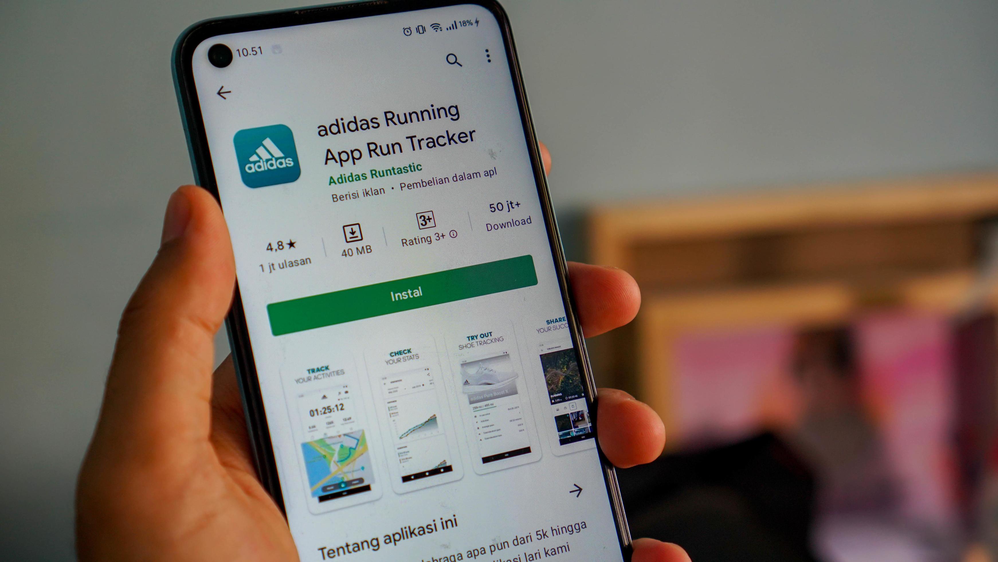 adidas corriendo. aplicación ejecutar la aplicación de Android rastreador. el icono de la en el primer plano de la pantalla del móvil se sostiene con la mano. 4888286 Foto de stock