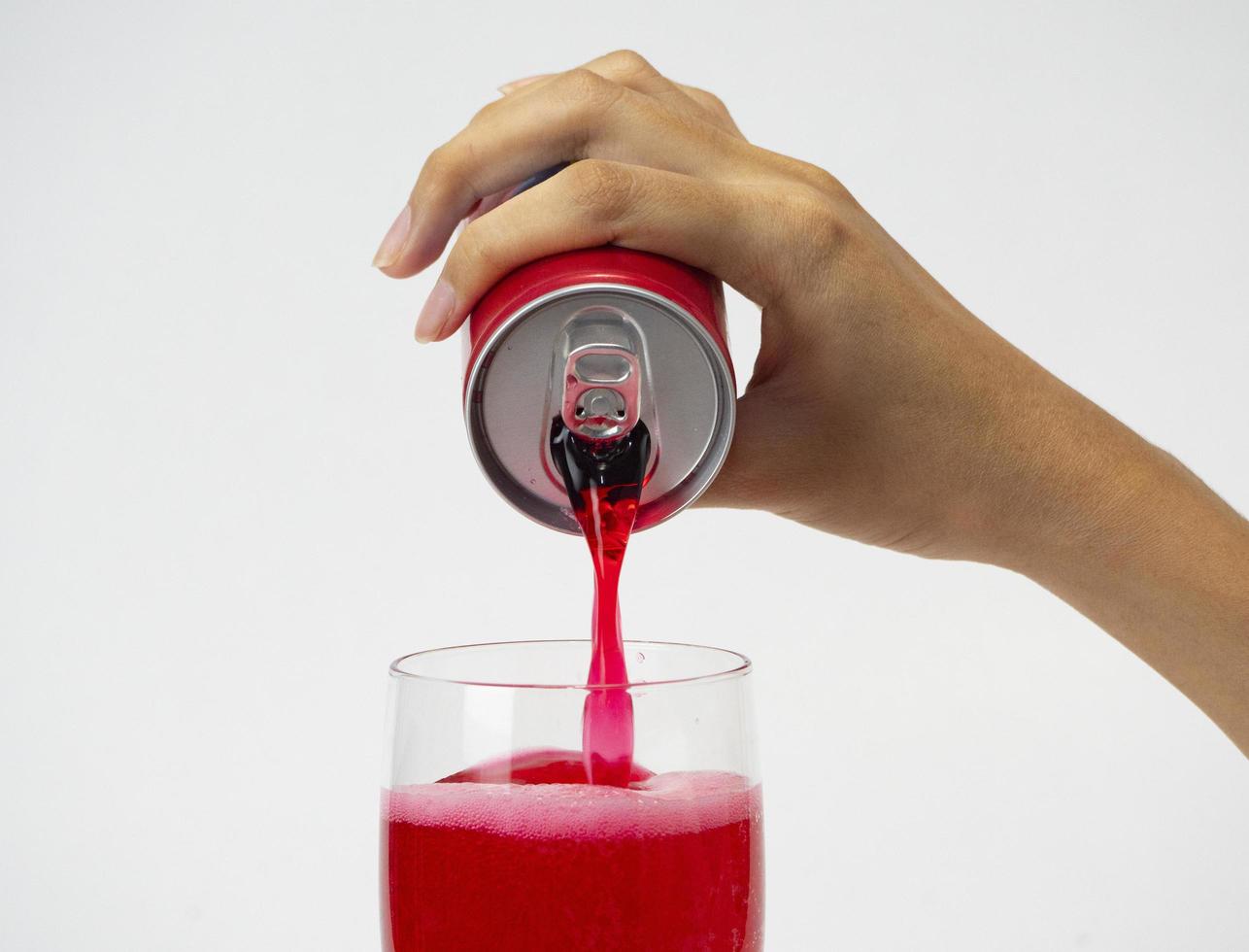 Close up of hand pouring soft drink into a glass photo