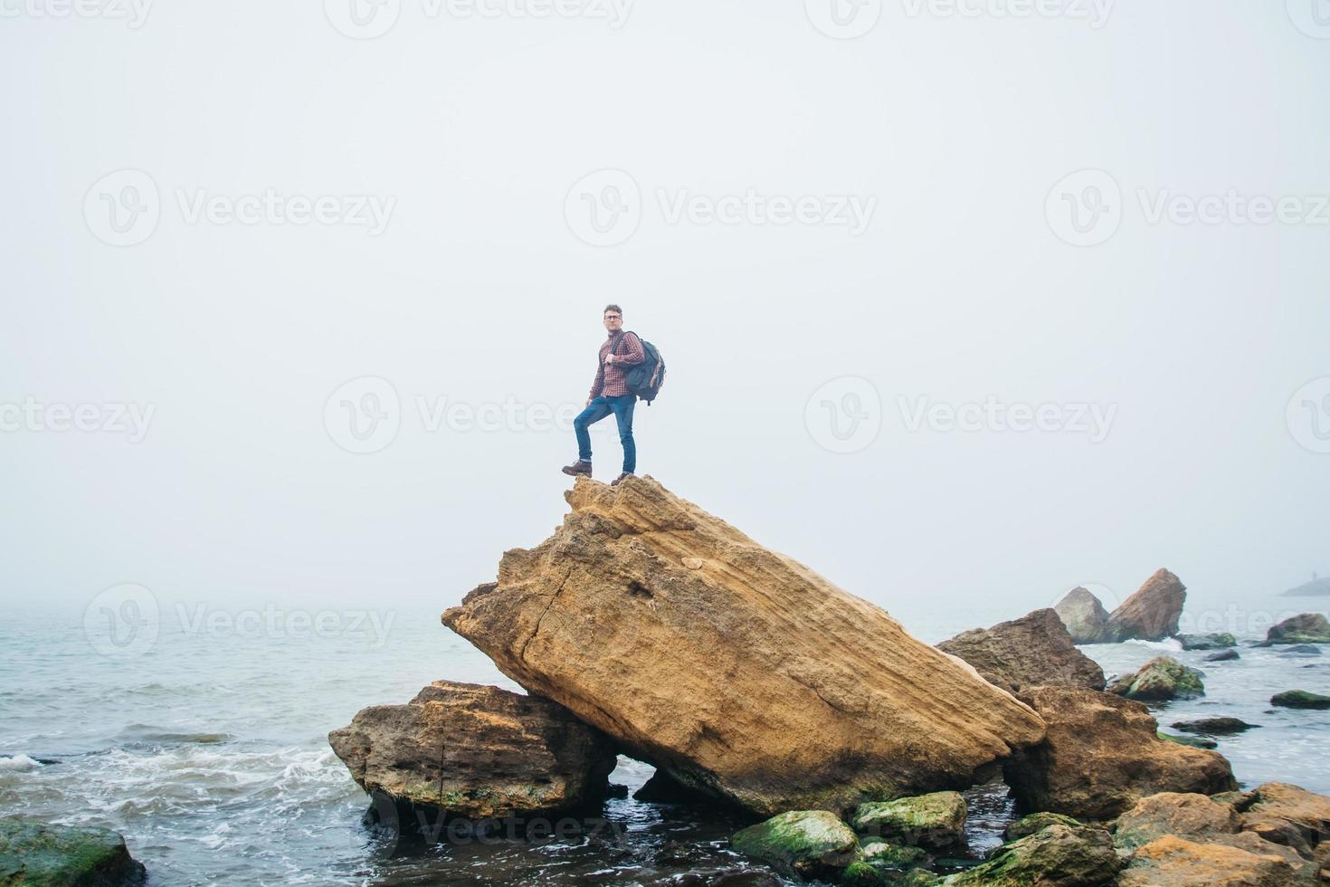 Traveler man stands on a rock on background a beautiful sea photo