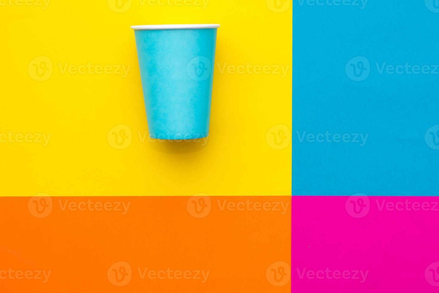 Vaso desechable de papel azul sobre un hermoso fondo multicolor. vista superior. estilo minimalista. copiar, espacio vacío para texto foto
