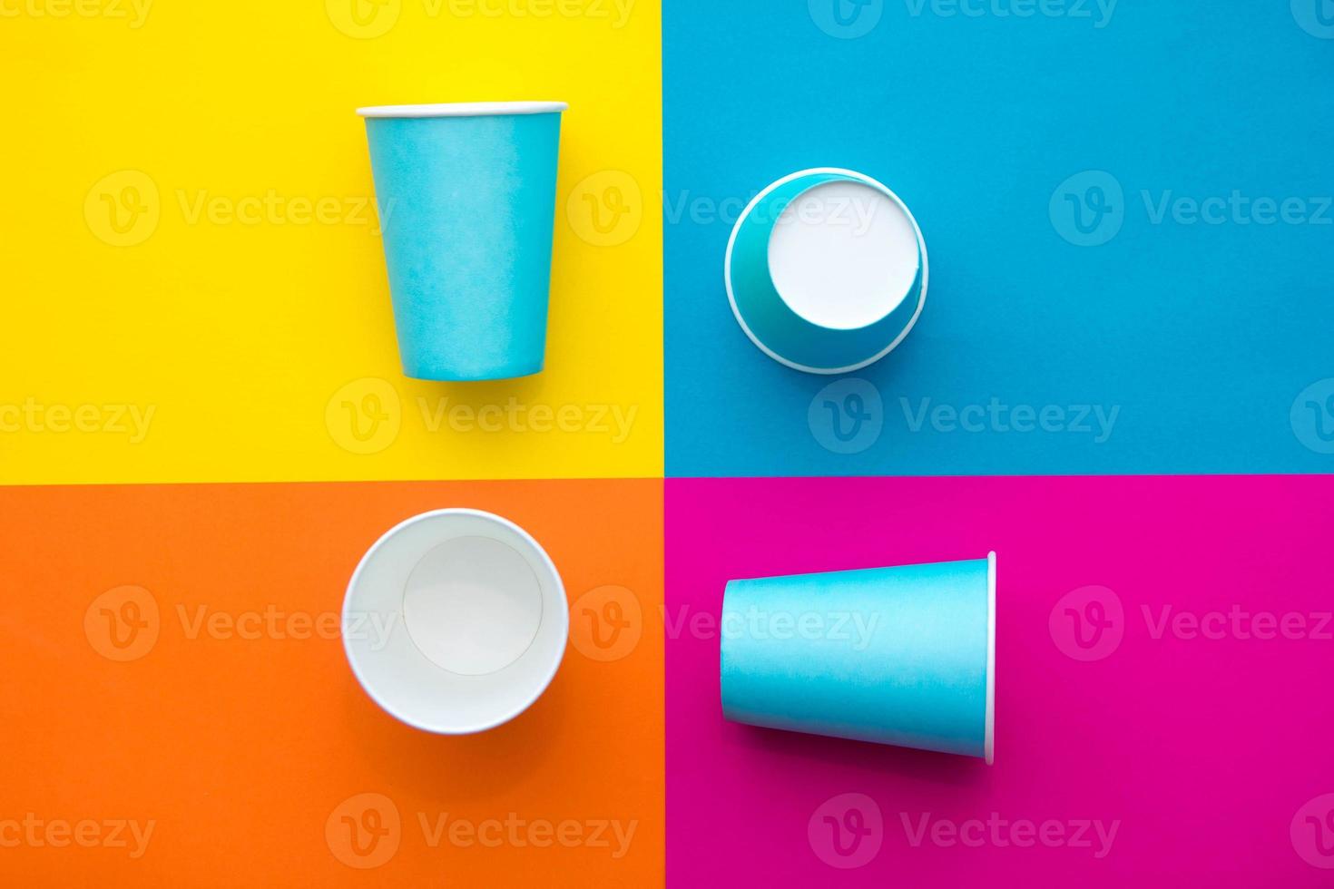 Vasos desechables de papel azul sobre un hermoso fondo multicolor. vista superior. estilo minimalista. copiar, espacio vacío para texto foto