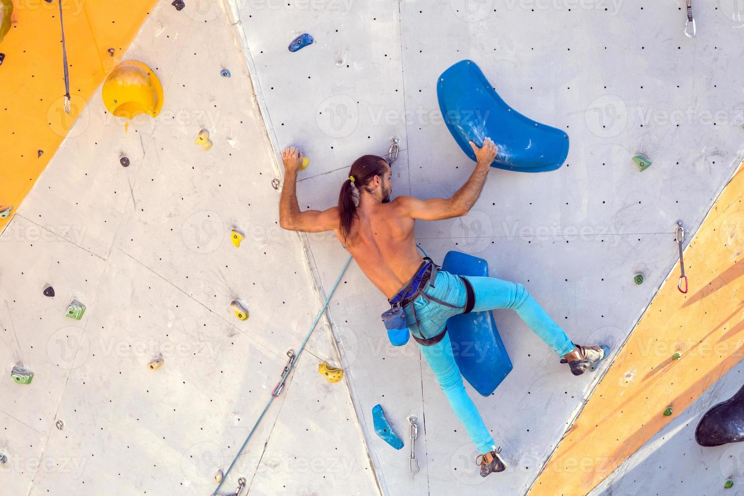 A man is climbing a climbing wall photo