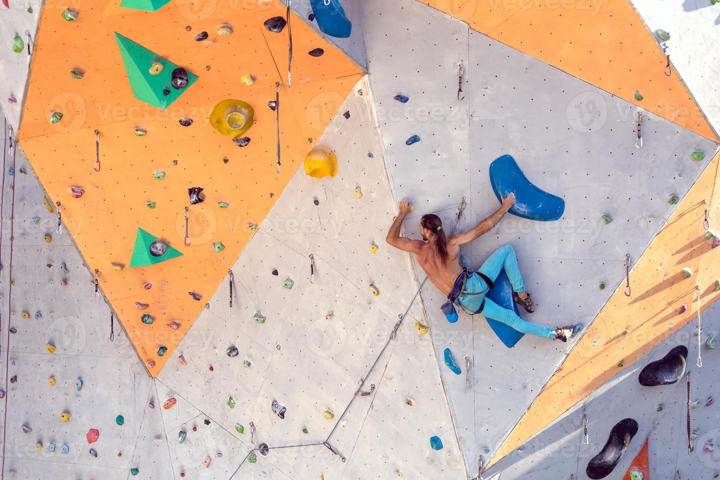 A man is climbing a climbing wall photo
