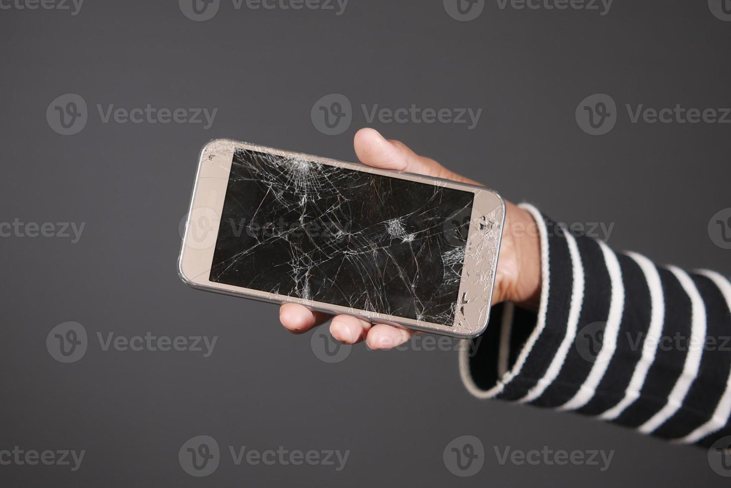 Close up of man hand holding broken smart phone. photo