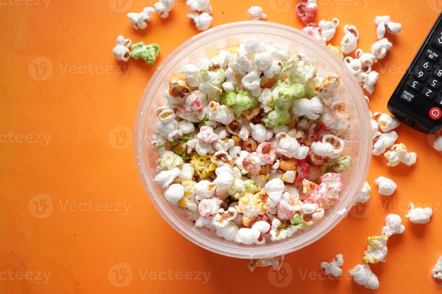 high angle view of popcorn and Tv remote on table photo