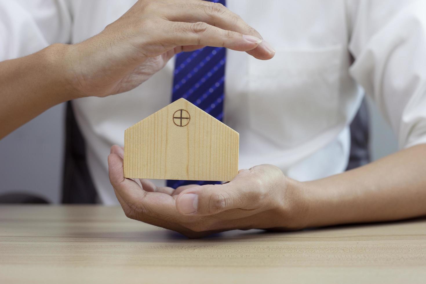 protecting gesture of man and house model. photo