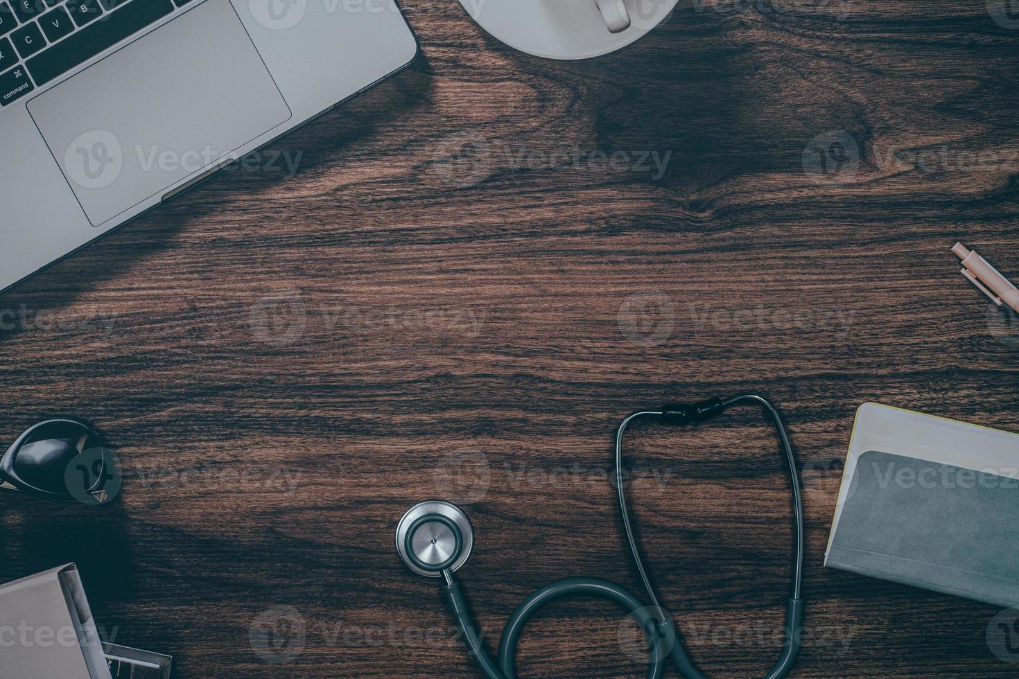 Estetoscopio y portátil sobre fondo de mesa de madera con espacio de copia foto