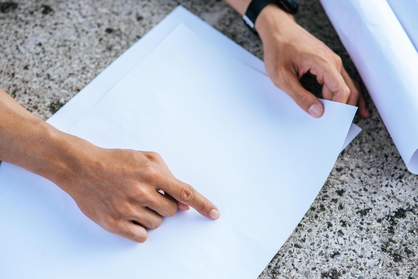 el arquitecto se sentó e inspeccionó el plano del edificio. foto