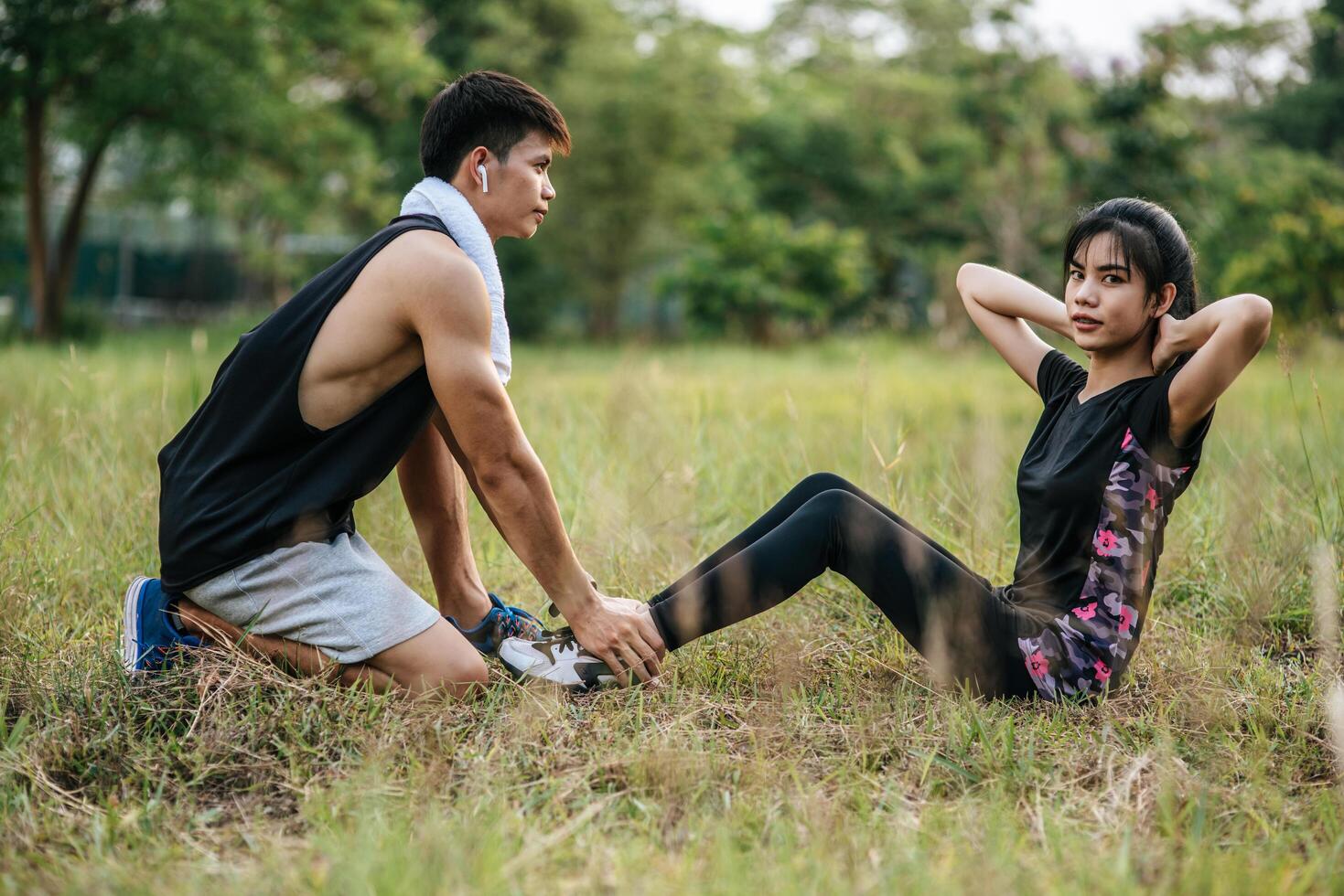 Men pushing women legs to exercise by pushing up. photo
