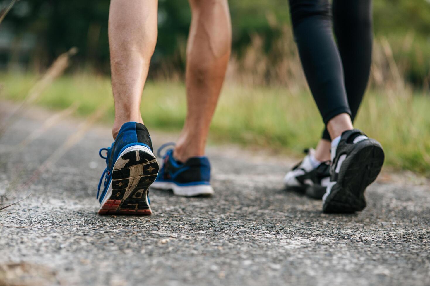 Runner woman and man feet running on road closeup on shoe. Sports healthy lifestyle concept. photo