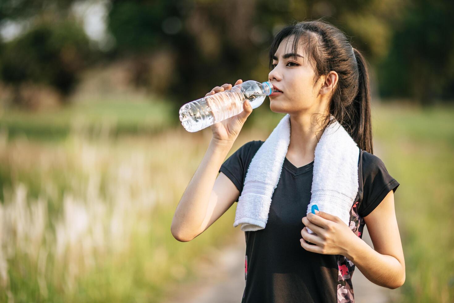 Women stand to drink water after exercise 4890101 Stock Photo at Vecteezy