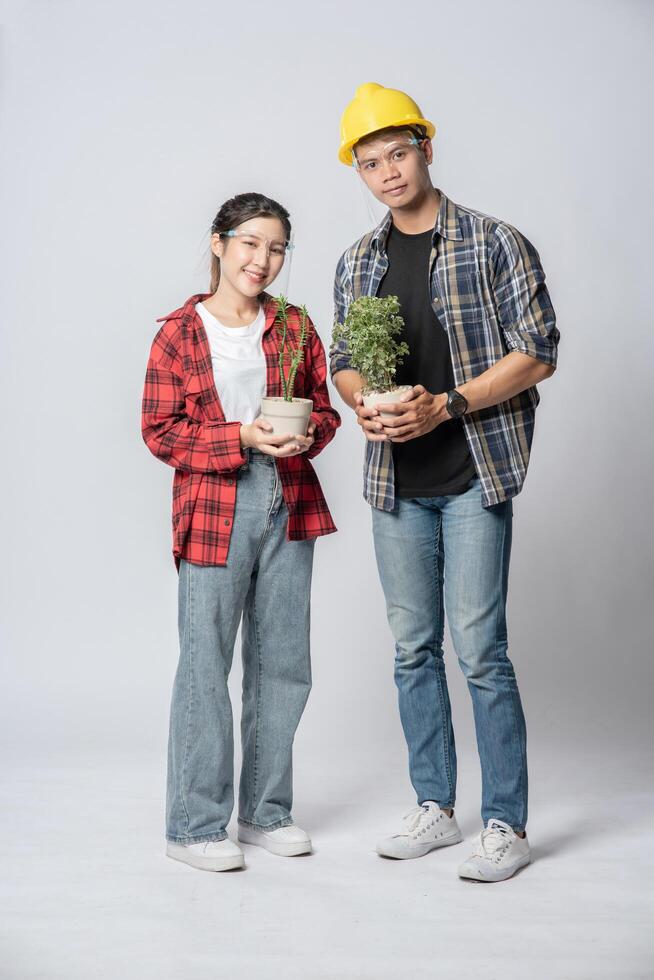 Men and women standing and holding plant pots in the house photo