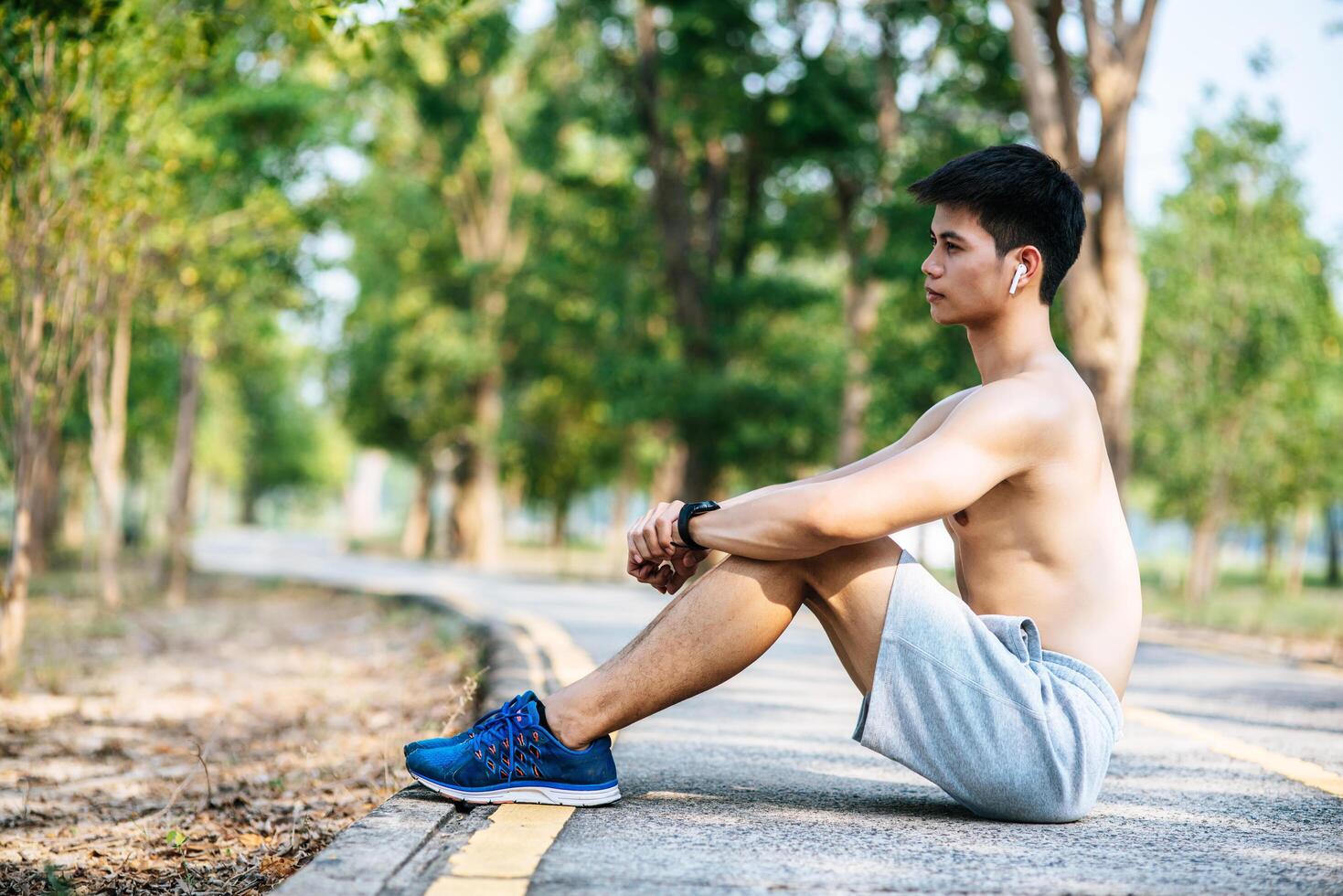 Men sitting and resting after exercising on the roadside. photo