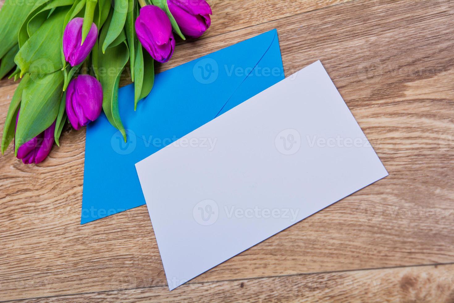 Blue envelope with tulips on a table photo