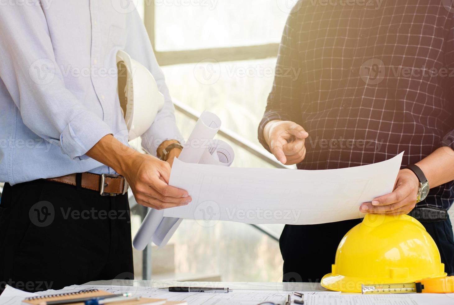 The chief engineer is listening to the advice from the team. To plan the structural work and the architect working on the blueprints mentioned at the construction site. photo