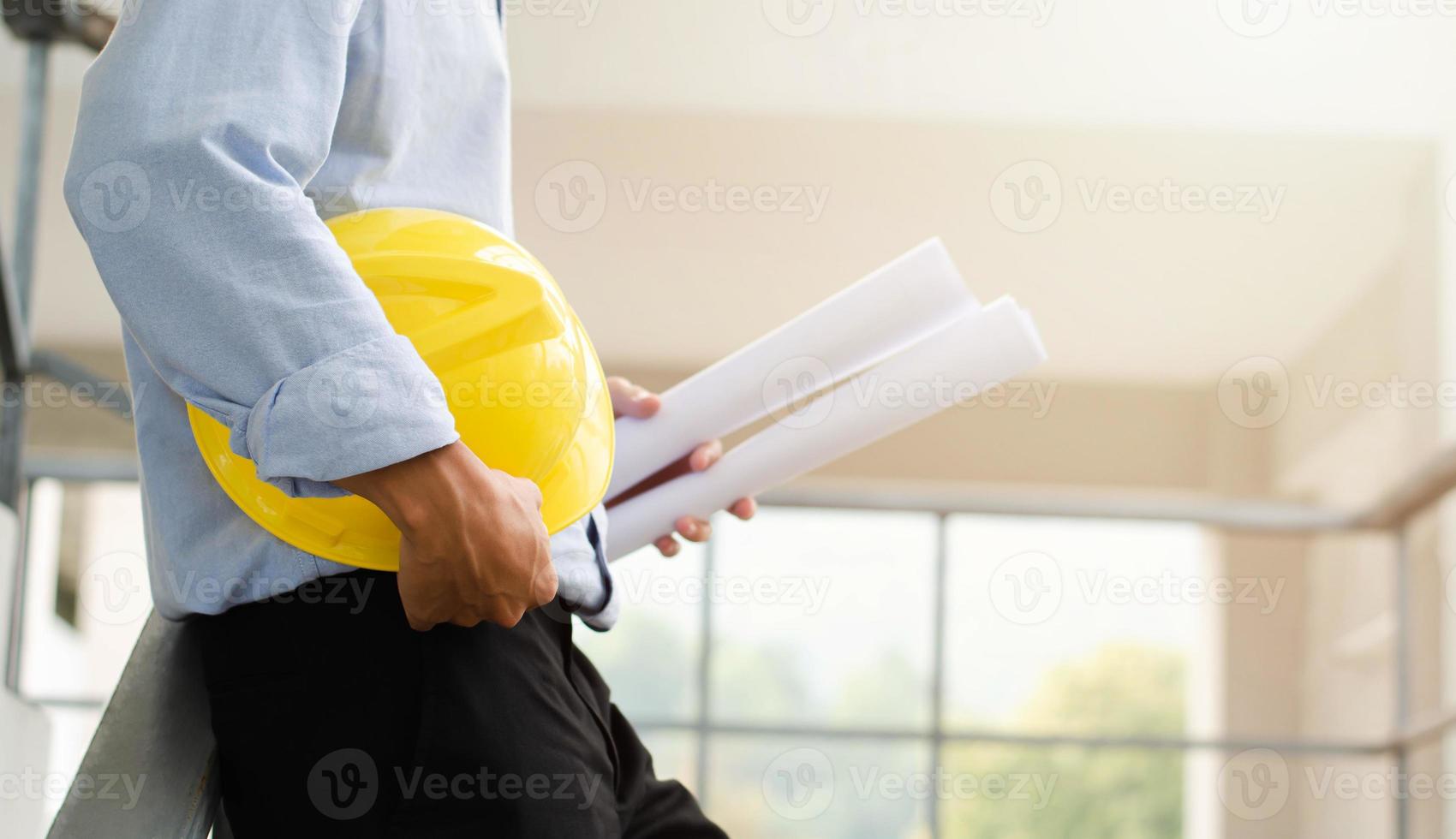 Close-up of an engineer working on a construction site with blueprints, planning, engineering and architecture concepts. photo