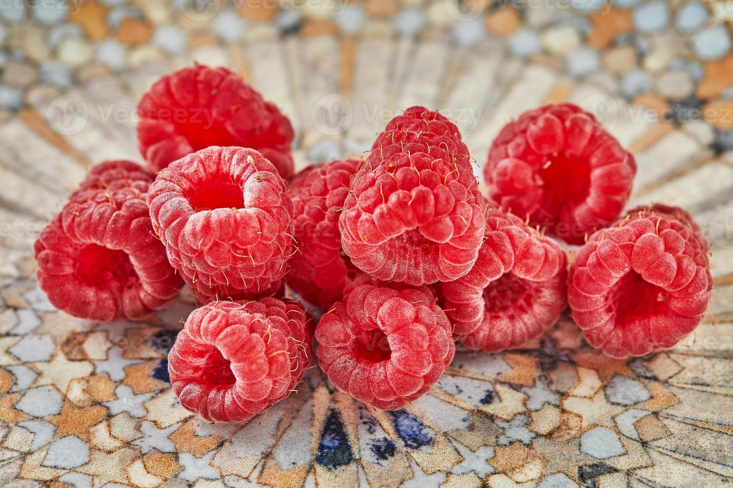 Fresh raspberries lying on plate for eating photo