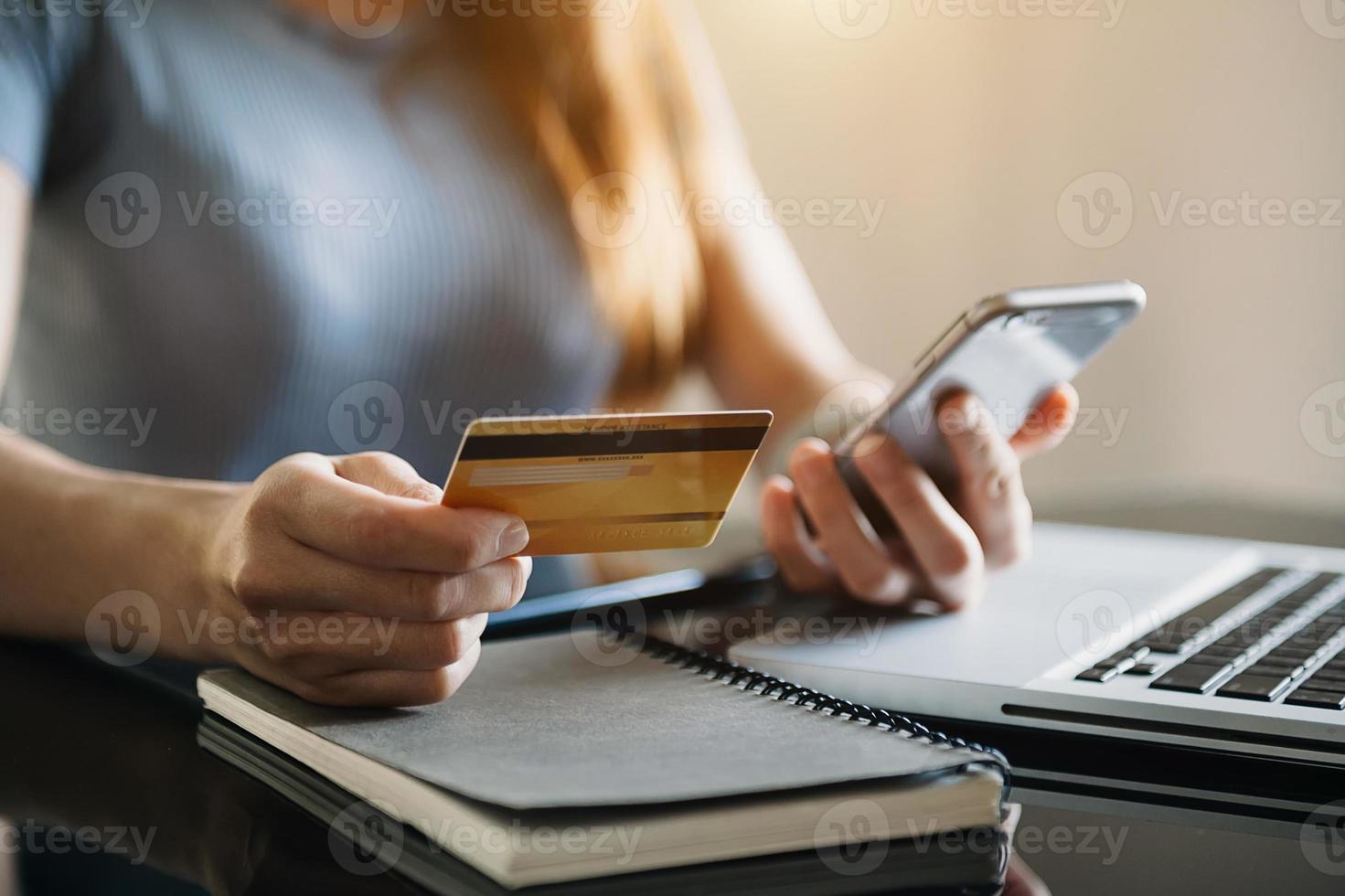 Manos de mujer de negocios con teléfono inteligente y tarjeta de crédito foto