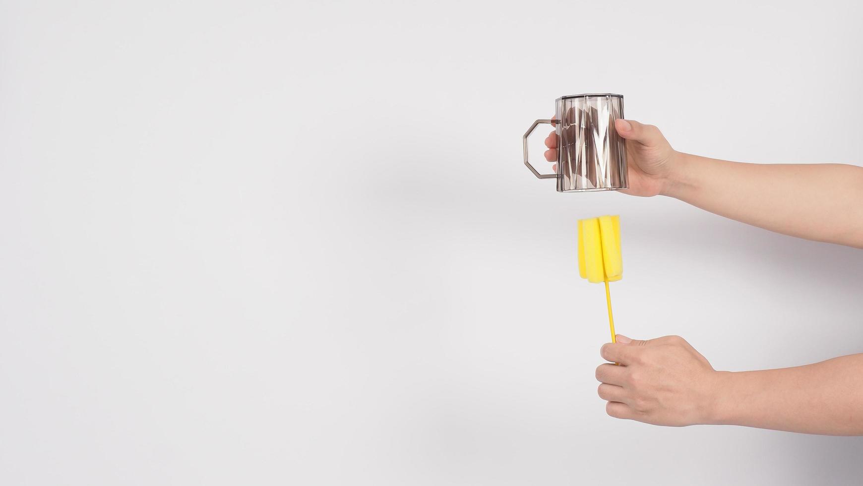 Clean and wash dish concept. Man hand washing drink glass on white background. photo