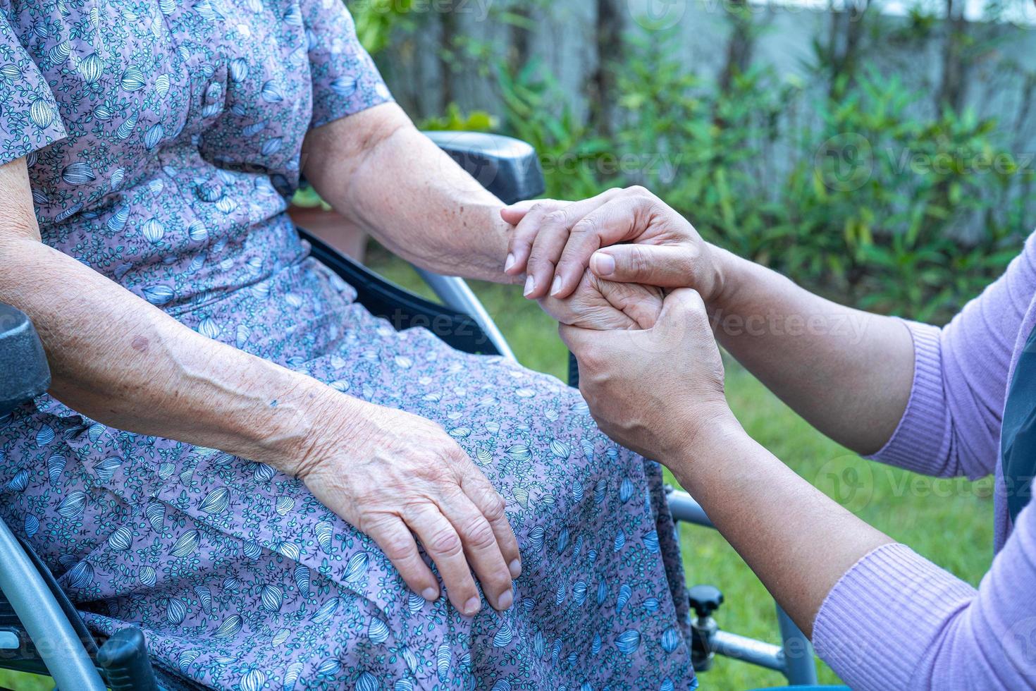 Caregiber holding hands Asian senior or elderly old lady woman patient with love, care, encourage and empathy at nursing hospital ward, healthy strong medical concept photo