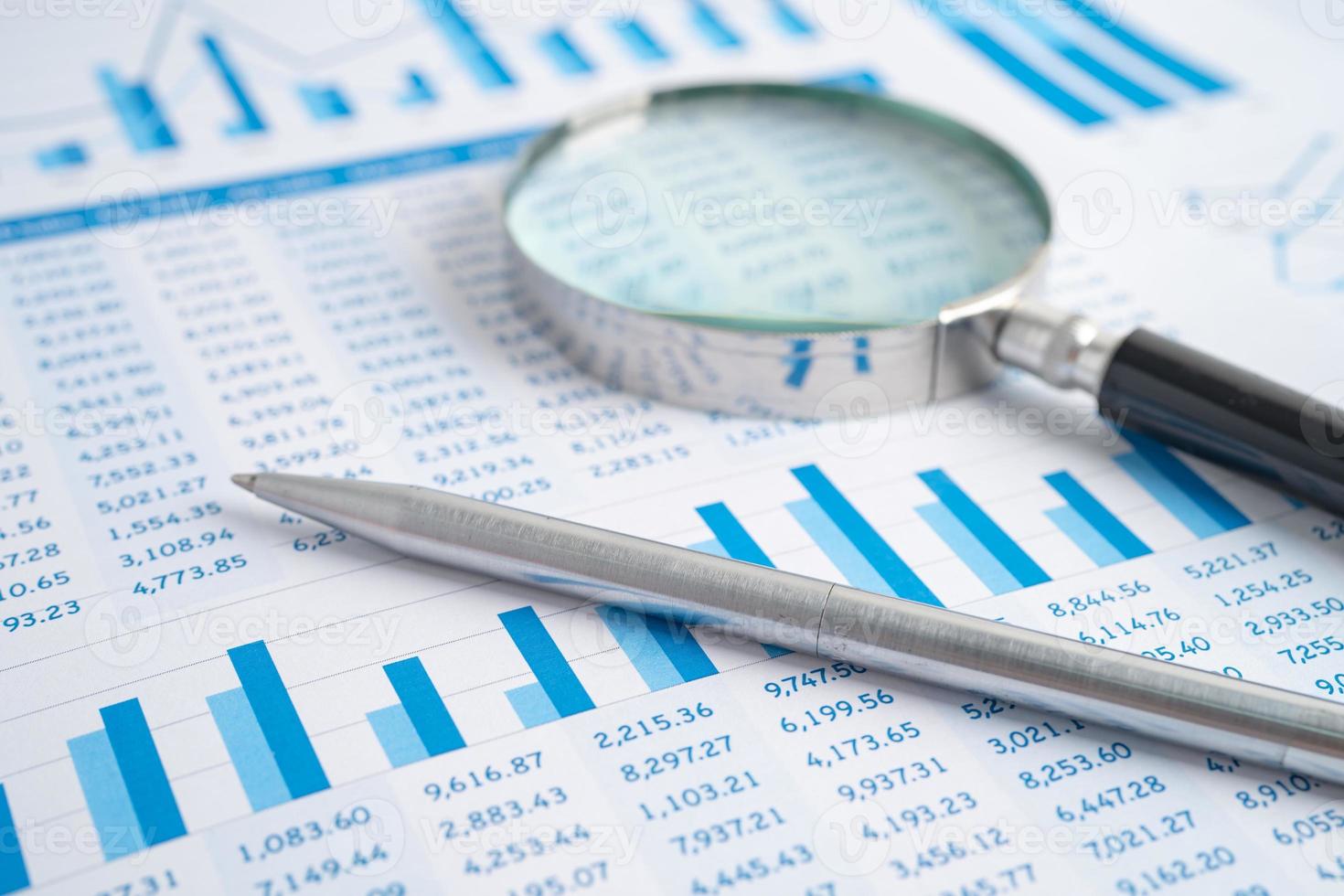 Magnifying glass on charts graphs paper. Financial development, Banking Account, Statistics, Investment Analytic research data economy, Stock exchange trading, Business office company meeting concept. photo