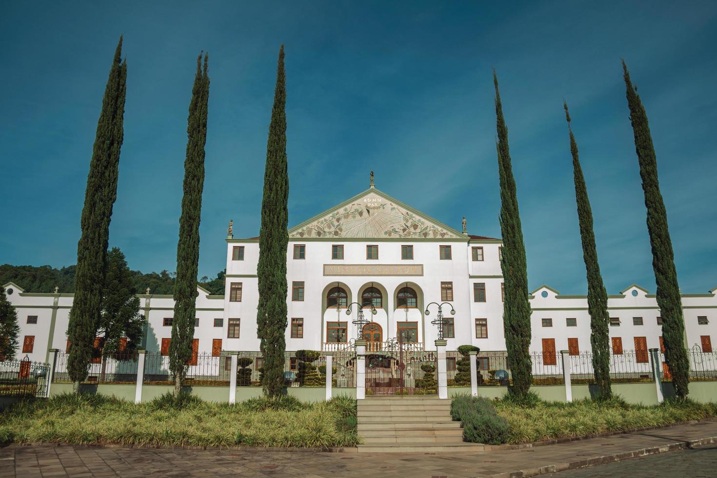 Bento Goncalves, Brazil - July 10, 2019. Street with the Salton Winery headquarter facade behind a fence and gardens near Bento Goncalves. A friendly country town famous for its wine production. photo