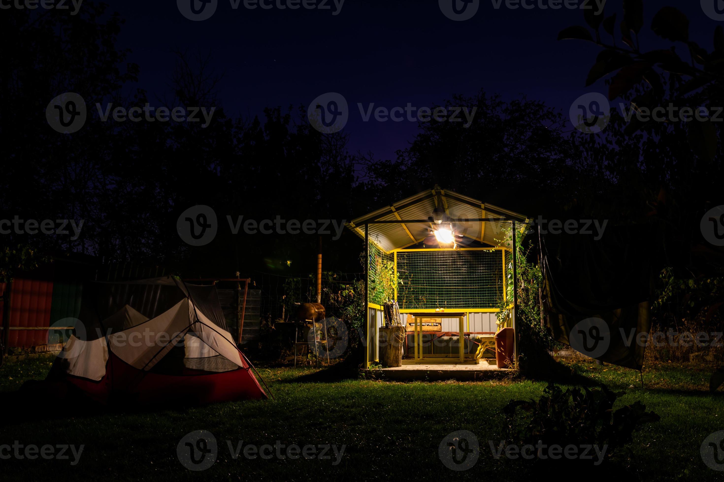 Tents versus shelter. Camping spot with white red tent and mini shelter  house in the campground surounded by nature at night. No person. 4898487  Stock Photo at Vecteezy