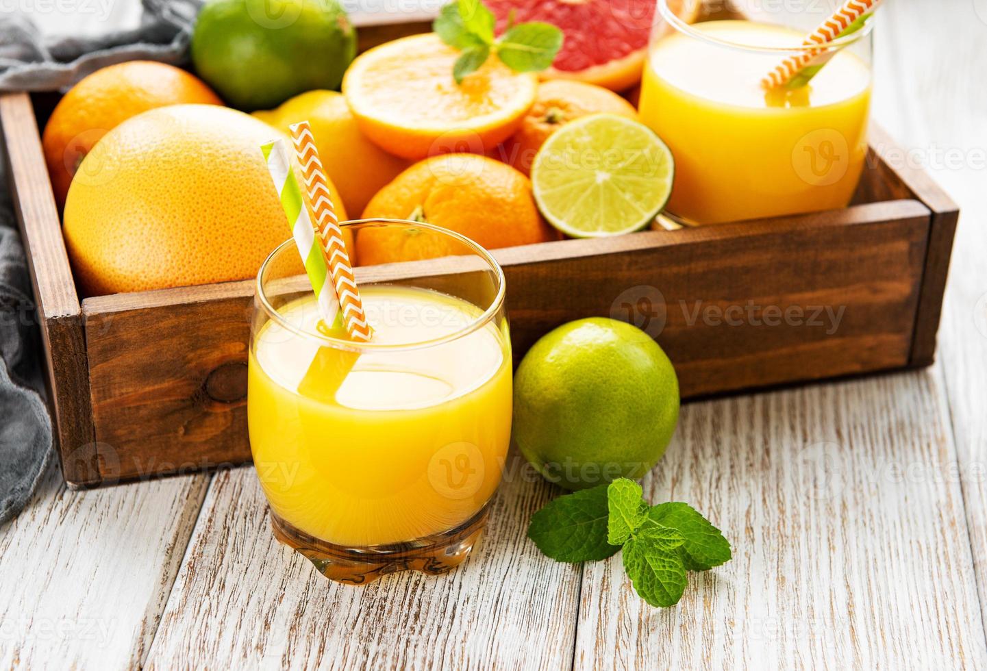 Glasses of juice and citrus fruits photo