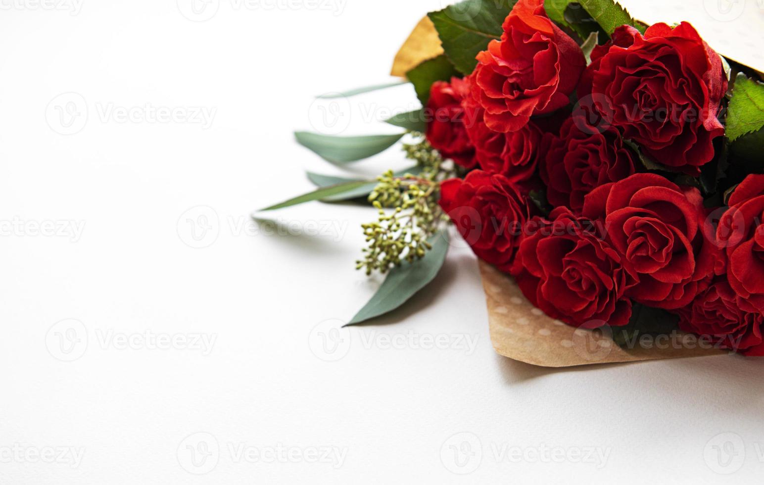 Red roses with eucalyptus on white background photo
