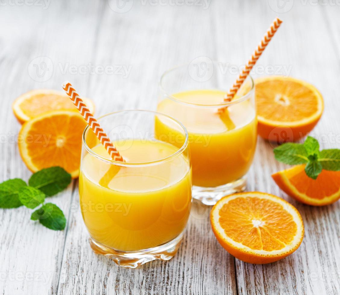 vasos de jugo y frutas de naranja foto