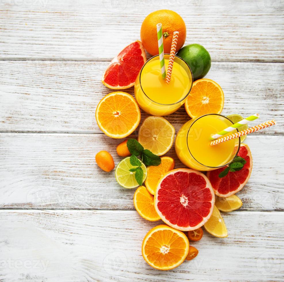 Glasses of juice and citrus fruits photo