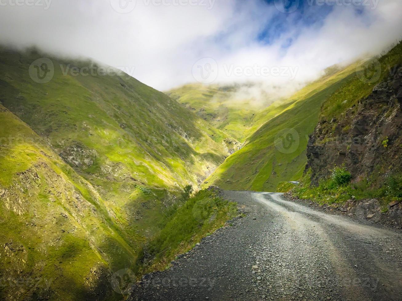 Pintoresco camino de ripio de montaña en la región de Tusheti rodeado por la naturaleza neblinosa del Cáucaso foto