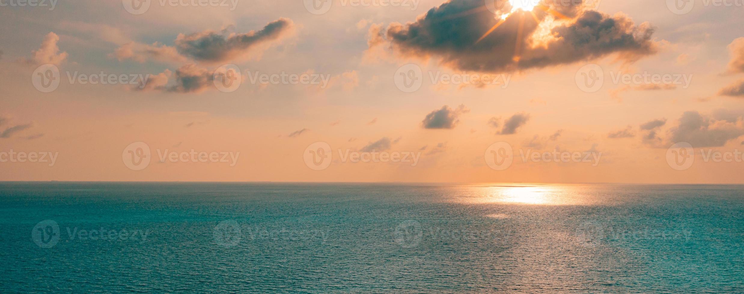 Aerial panoramic view of sunset over ocean. Colorful sky, clouds and water. Amazing serene scenic photo