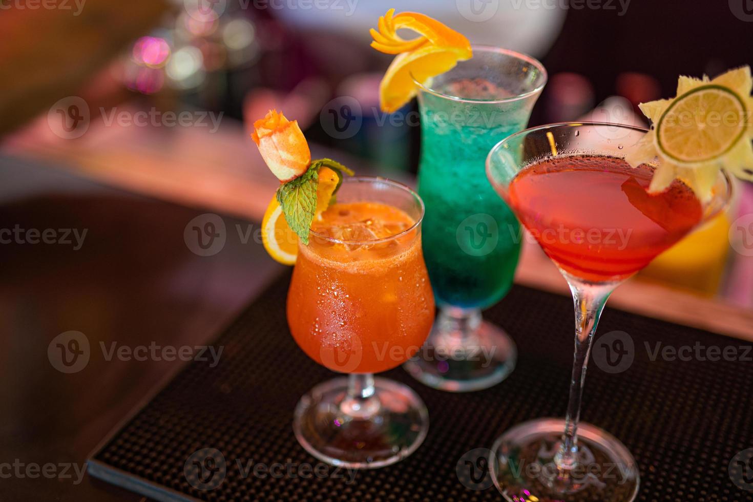 Different delicious cocktails on black table in bar. Party, nightclub colorful banner concept photo