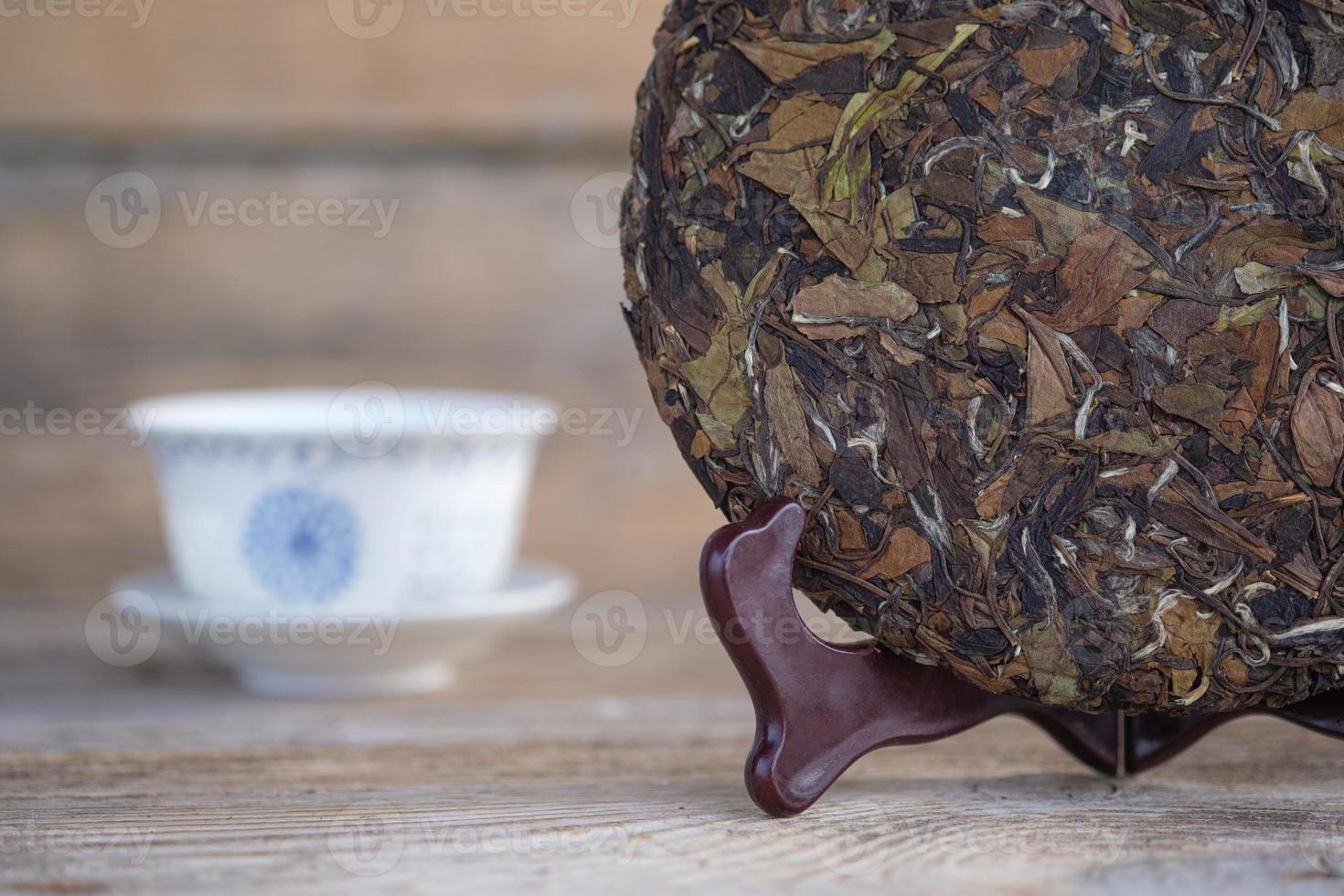 natural Chinese white tea in the form of a pancake. pressed round tea on a wooden stand photo