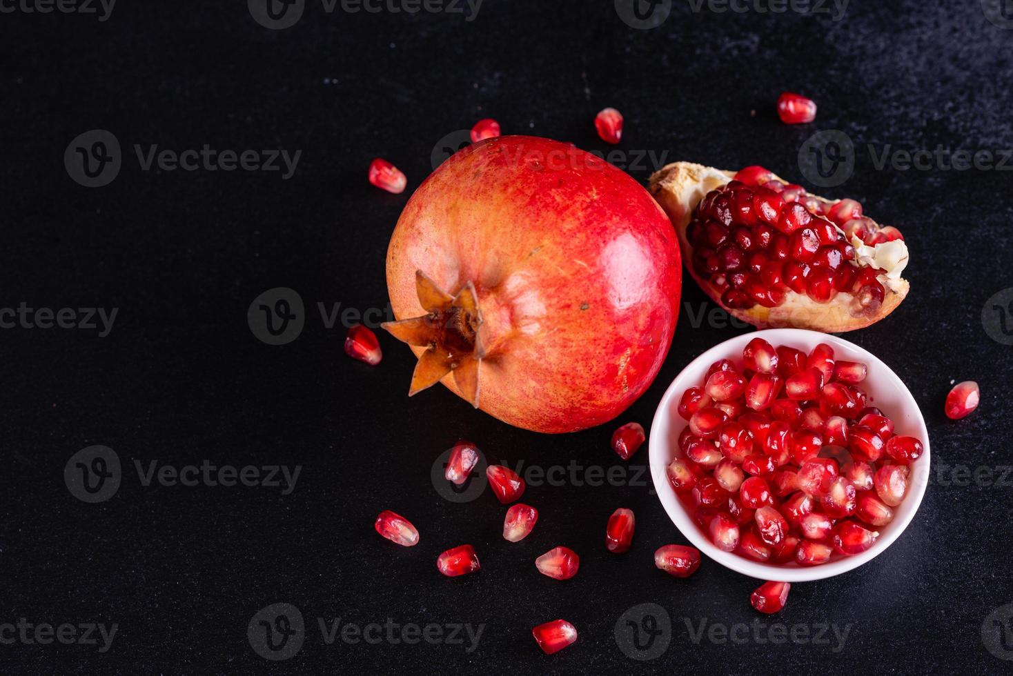 Tasty fresh red pomegranate on a dark concrete background photo