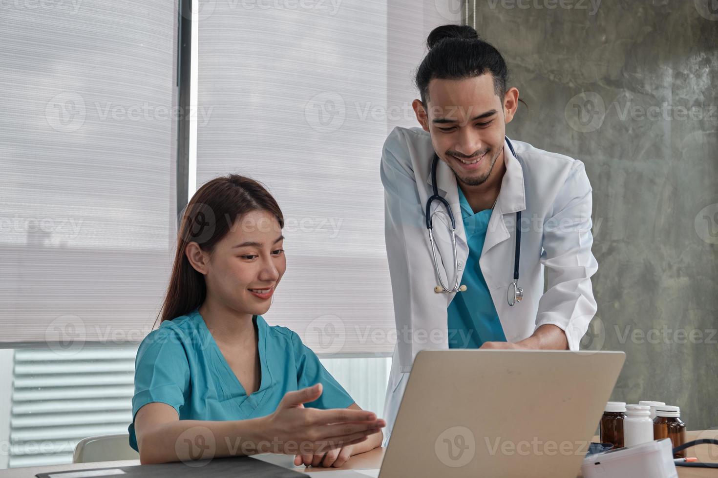 socios del equipo de atención médica. dos médicos uniformados jóvenes de etnia asiática son compañeros de trabajo que discuten sobre la medicación en la oficina de la clínica del hospital. Las personas especializadas son expertos y profesionales. foto