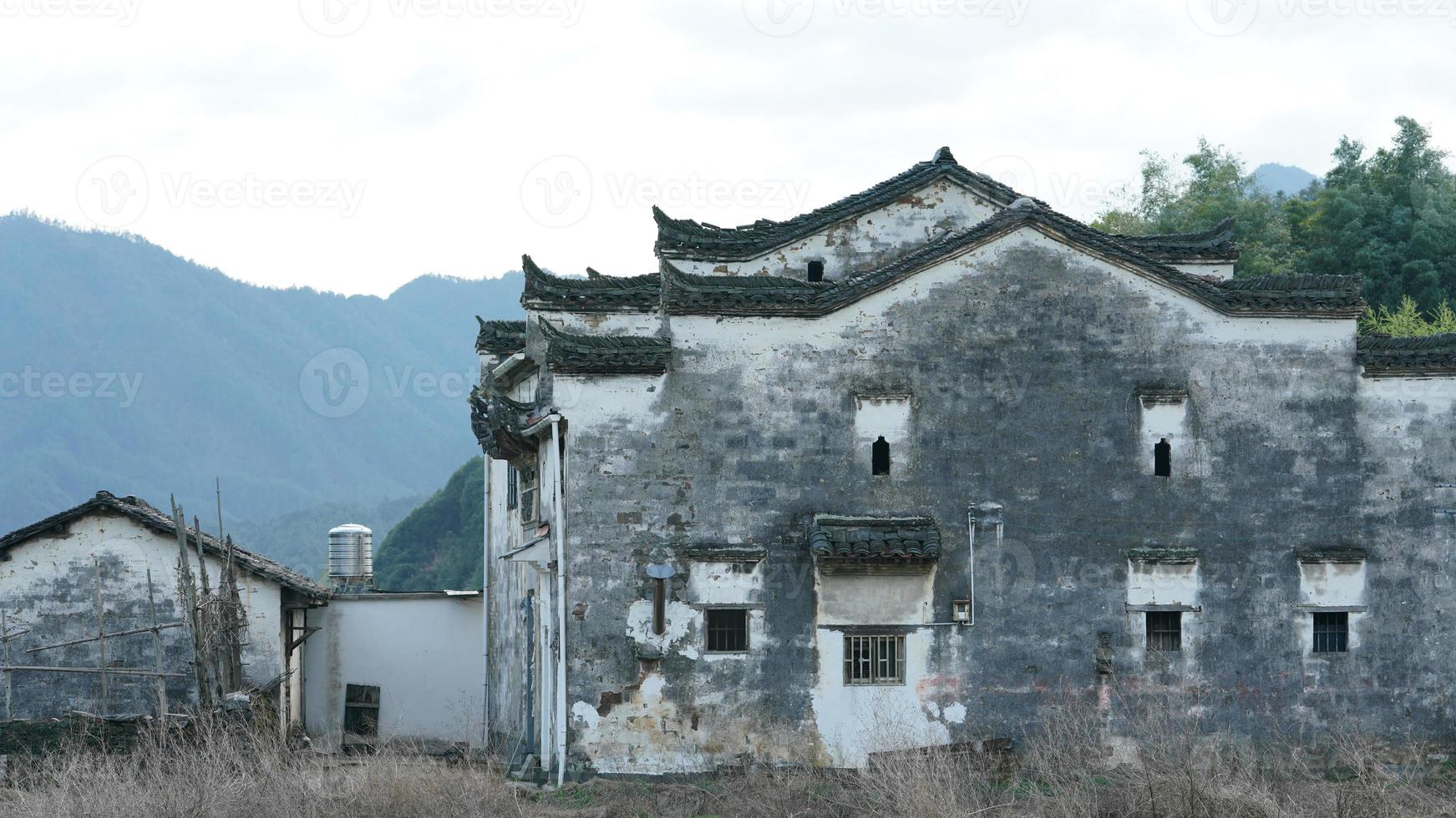 The  beautiful and old traditional Chinese village view with the mountains around it located in the countryside of the southern China photo
