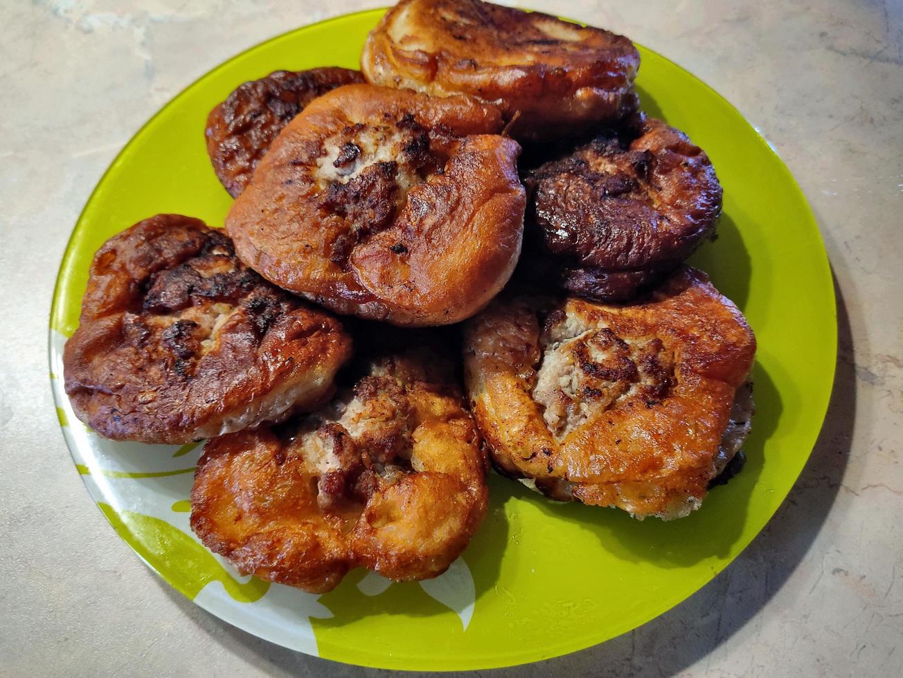 Fried dough with meat on a green plate. photo