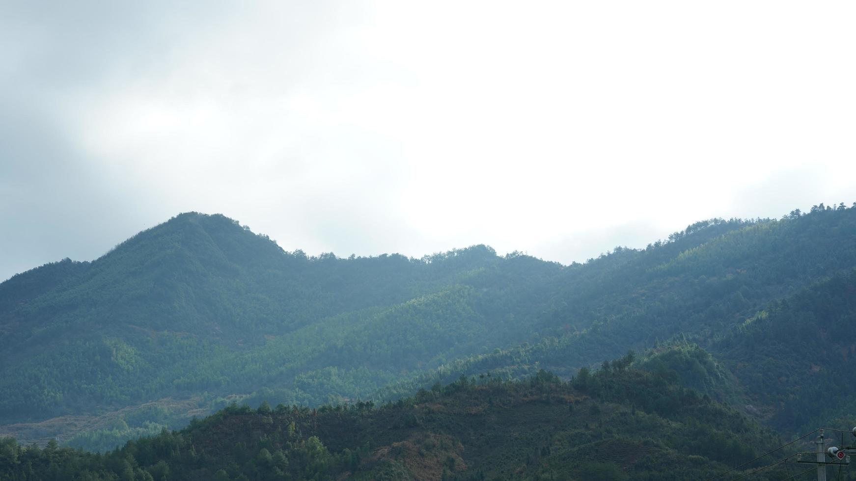 la hermosa vista de las montañas con el bosque verde y el campo de flores en el campo del sur de China foto